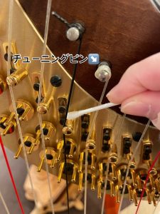 綿棒でチューニングピン周りのくすみを落とす様子