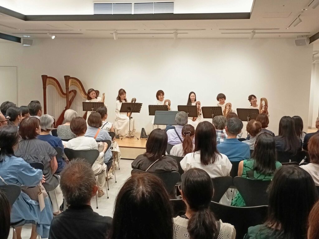 ハープの日のコンサートで演奏するアンサンブルと客席
