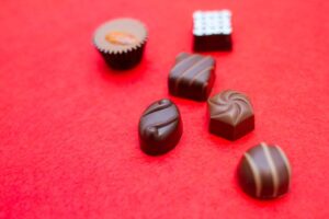 赤い背景に並べたひと口チョコレート