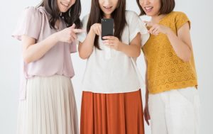 スマートフォンを一緒に見る3人の女性