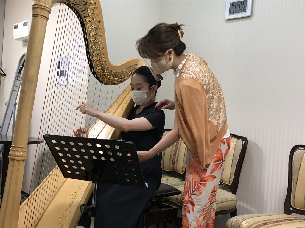 講師が手元を見せながら指導する体験レッスンの様子