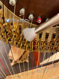 柔らかいブラシでブリッジピンのホコリを取り除く様子