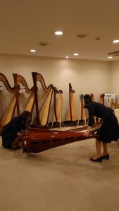 二人でグランドハープを横に倒す様子