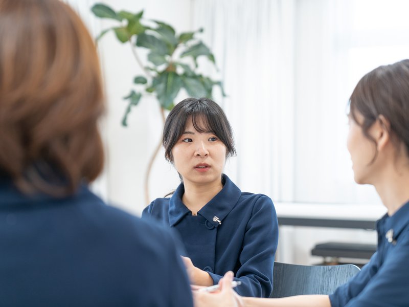 打ち合わせの場で、身ぶりを交えて話す銀座十字屋のスタッフ