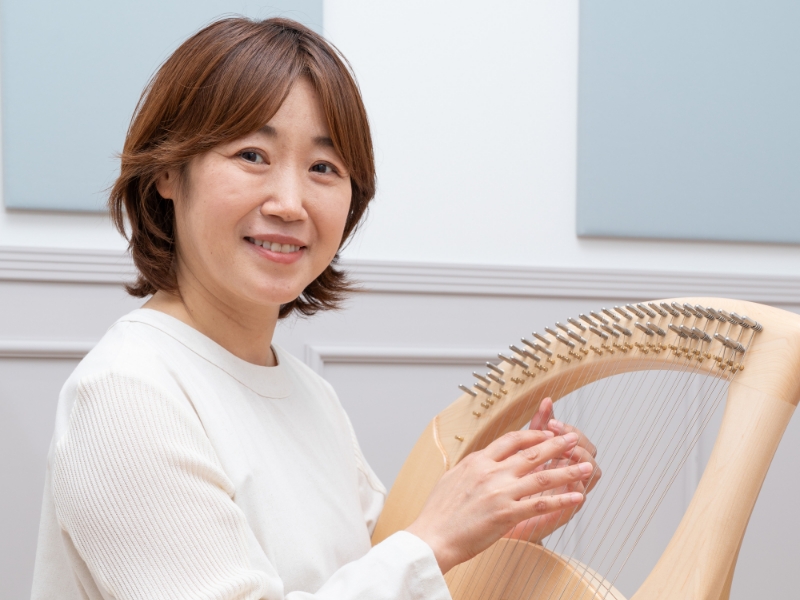 ライアーを膝にのせて構える女性